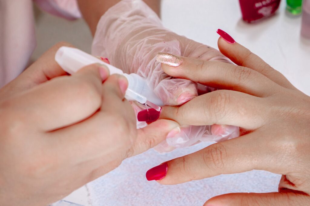Gel polish being carefully applied to nails with a precision brush