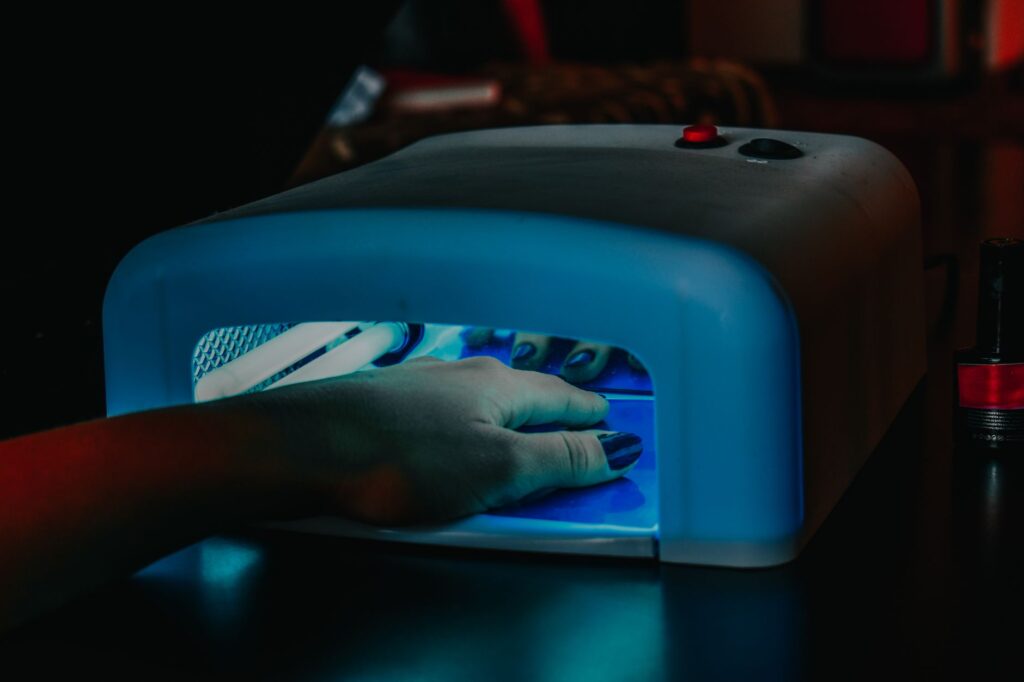 Nails being cured under a UV lamp during gel manicure service